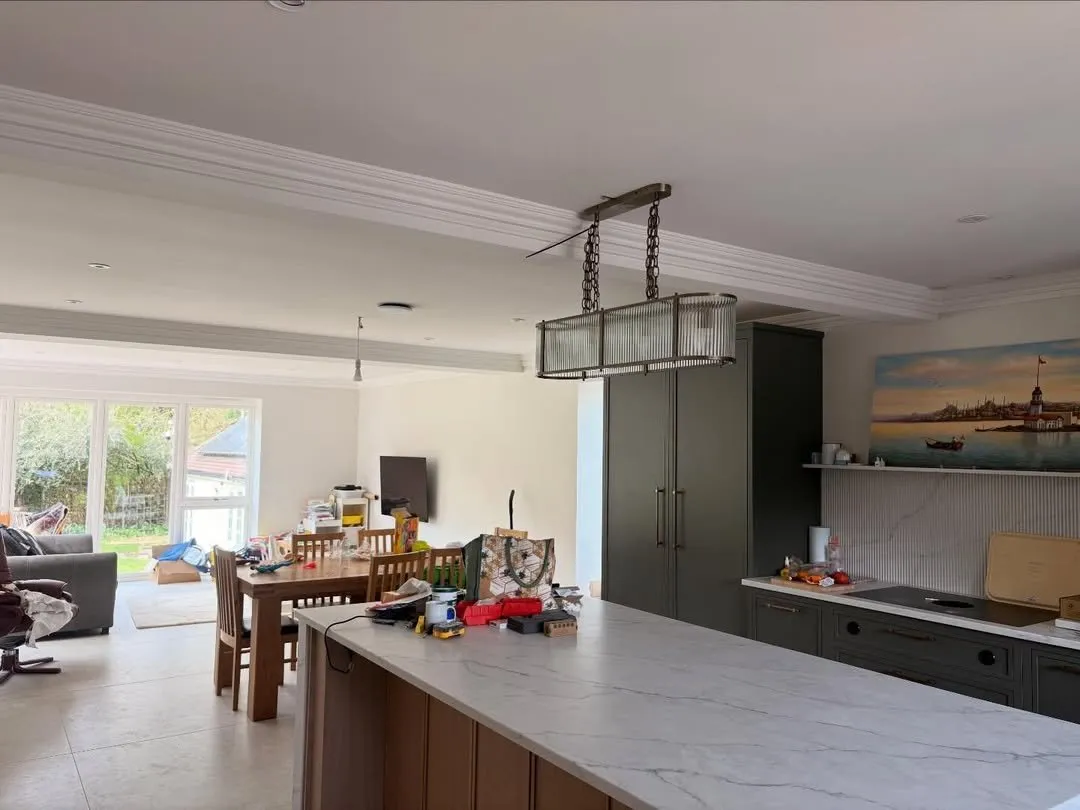 Open-plan kitchen with new recessed and pendant lighting after a refurbishment